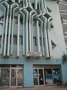 photo d'un immeuble avec une boutique en rez-de-chaussée affichant « centre vidéo cassette »