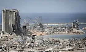 Le cratère d'explosion (au premier plan) et le silo à grains du port de Beyrouth (à l'extrême gauche de la photo) après la catastrophe.