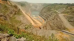 Mine d'or à ciel ouvert parcourue par de nombreux engins de chantier.