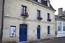 Photographie en couleurs d'un bâtiment à étage avec l'inscription MAIRIE gravée au-dessus d'une porte.