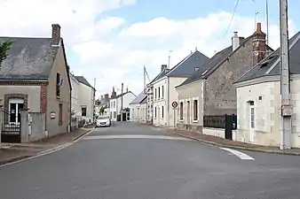 Photographie en couleurs d'une rue bordée de maisons de part et d'autre.