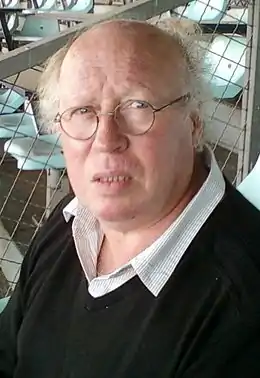 Photo d'un homme assis dans une tribune d'un stade.