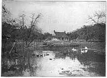Ancienne photographie représentant une ferme bordée d'un étang.