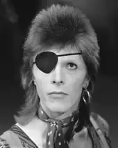 Portrait en noir et blanc de David Bowie avec un cache-œil sur l'œil droit.
