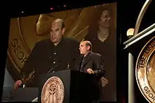  Photo de David Simon donnant un discours derrière un pupitre.