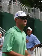 Portrait de profil de Davis Love III, portant des lunettes noires et une casquette.