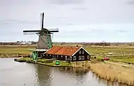 Un moulin au bord d'un point d'eau.