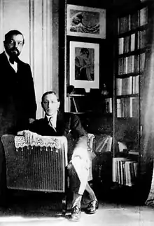 Photographie en noir et blanc montrant Debussy debout et Stravinsky assis.