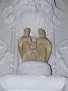 Décoration sculpturale située au-dessus des reliques de l'église. La Sainte Famille : la Vierge Marie (à gauche), l'Enfant Jésus (au centre) et saint Joseph (à droite).