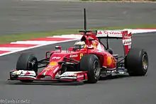 Photographie d'une monoplace de Formule 1 rouge, vue de trois-quarts.