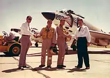 Photographie couleur d'hommes se serrant la main devant un avion pour immortaliser une livraison d'avion.