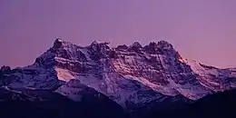 Des montagnes enneigées devant un ciel violet.