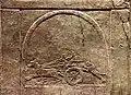 Représentation d'une stèle placée dans le jardin où se déroulent les chasses au lion, représentant le roi sur un char en train de chasser un lion.