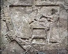 Un devin et son assistant préparent un animal en vue d'un sacrifice divinatoire. Détail d'un bas-relief de Nimroud, IXe siècle av. J.-C. British Museum.
