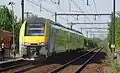 Un train omnibus quitte la gare d'Acren en direction d'Enghien.