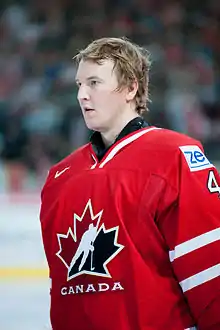 photographie d'un gardien de hockey sur glace avec le maillot rouge du Canada et sans casque