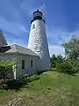 phare blanc avec un cabanon et une lanterne noire