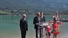 trois personnes debout devant un lac