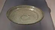 Plat. Décor estampé, barbotine blanche sur grès à glaçure transparente. Céramique de type buncheong, D. 16,5 cm. XVe siècle. British Museum.