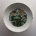 Plat à décor de fruits, fleurs, dragons et nuages. Porcelaine « Famille verte » sur biscuit "à secret" Règne Kangxi (1662-1722). Musée Guimet