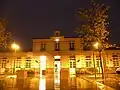 Façade de la gare illuminée la nuit.