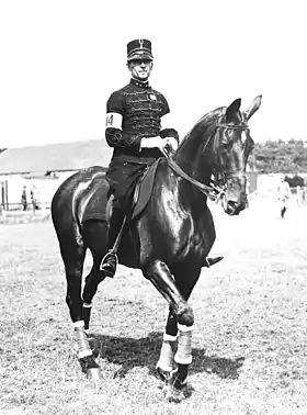 Photo en noir et blanc représentant un militaire sur son cheval monté en bride.
