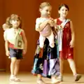 Trois enfants portent leurs poupées