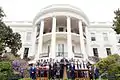 Donald Trump faisant un discours devant l'équipe des Patriots en costumes et la Maison Blanche.