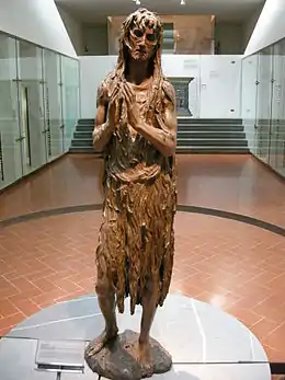 Statuette en bois d'une femme âgée faisant pénitence