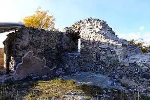 Murs formant un angle. Au milieu de celui de gauche se trouve une petite ouverture.