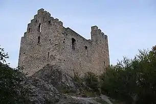 Bâtiment en pierre sans toit. La face droite du bâtiment a un sommet triangulaire qui laisse deviner un toit à deux pans.