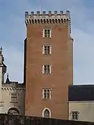 Photographie en couleur d'une tour en briques rouges d'un château.