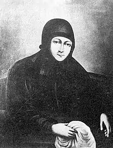 Portrait d'une religieuse habillée de noir, tenant un tissu blanc.