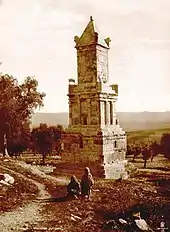 Photo sépia ancienne d'une tour ouvragée avec deux femmes ou filles au premier plan.