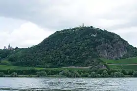 Le Drachenfels vu depuis le Rhin avec les ruines du château Drachenfels à son sommet et le château de Drachenburg sur la gauche.