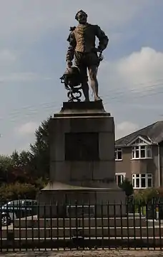 Statue d'un homme portant une épée, la main posée sur un globe terrestre.