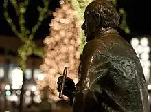 Photo de la partie supérieure (buste) d'une statue d'un homme vu de profil, cigare en main.