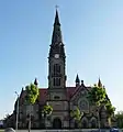 Vue de la façade nord : à gauche l'entrée catholique, à droite l'ancienne entrée luthérienne, entre les deux le clocher, qui ne relève d'aucun des deux cultes