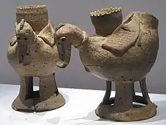 Photographie de deux céramiques en forme de canards. Elles sont visibles dans la vitrine d'un musée.