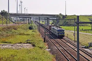 La jonction "Y Dudzele". À gauche: la ligne 51B de Knokke. À droite et à l'avant-plan: la ligne 51A venant de Zeebrugge-Strand. La photo est prise en direction de Bruges. Le train de fret, tracté par deux locomotives de la série 26, roule en direction de Zeebrugge.