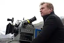 Photographie d'un homme à côté d'une caméra IMAX.