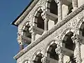 Détail de la façade en marbre sculpté et marqueté de la cathédrale de Lucques. Style roman italien, XIIe-XIIIe siècle.