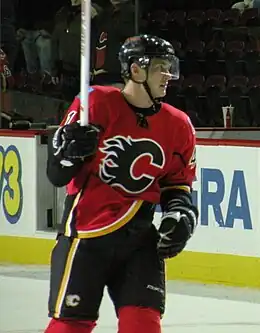 Photographie de Boyd en tenue de hockey qui regarde à gauche et lève son bâton