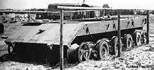 photographie en noir et blanc montrant un châssis de char inachevé sans tourelle et sans chenille vu de trois-quart avant