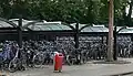 La gare et son parking à vélo, à l'entrée du quartier (ici durant les vacances, le 10 juillet)