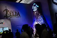 Plusieurs personnes testent le jeu à l'E3 2016 avec une représentation d'un sanctuaire en arrière plan.