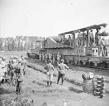 Présentation d'un canon de 320 mm modèle 1870/84 sur voie ferrée à une mission militaire chinoise, en août 1917 à Thierville-sur-Meuse. Les servants actionnent les vérins abaissant les six traverses d'appui.