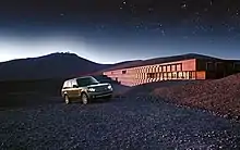 Photographie montrant une Land Rover devant l'hôtel, durant une nuit étoilée.