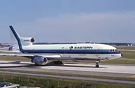 Photographie en couleur d'un avion civil Eastern Air Lines se déplaçant sur les pistes d'un aéroport.