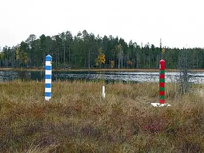 Jalons finlandais (bleu-blanc) et russe (rouge-vert) à l'extrémité orientale de la Finlande sur une île sans nom dans le lac Virmajärvi à Ilomantsi